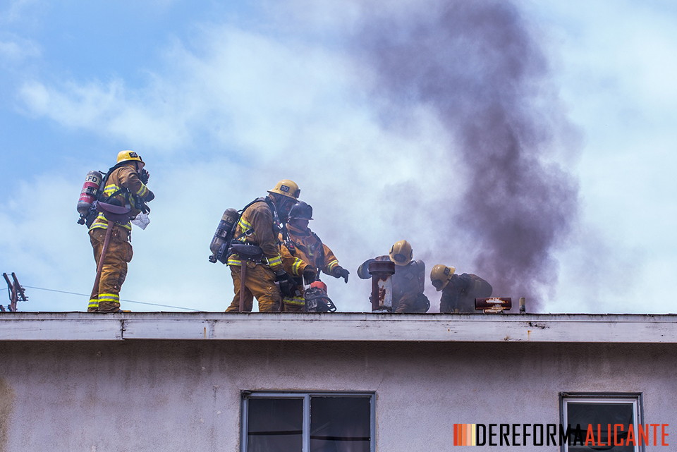 Bomberos apagando un incendio en una viviena provocado por un cortocircuito en un cuadro eléctrico sin interruptor magnetotérmico.